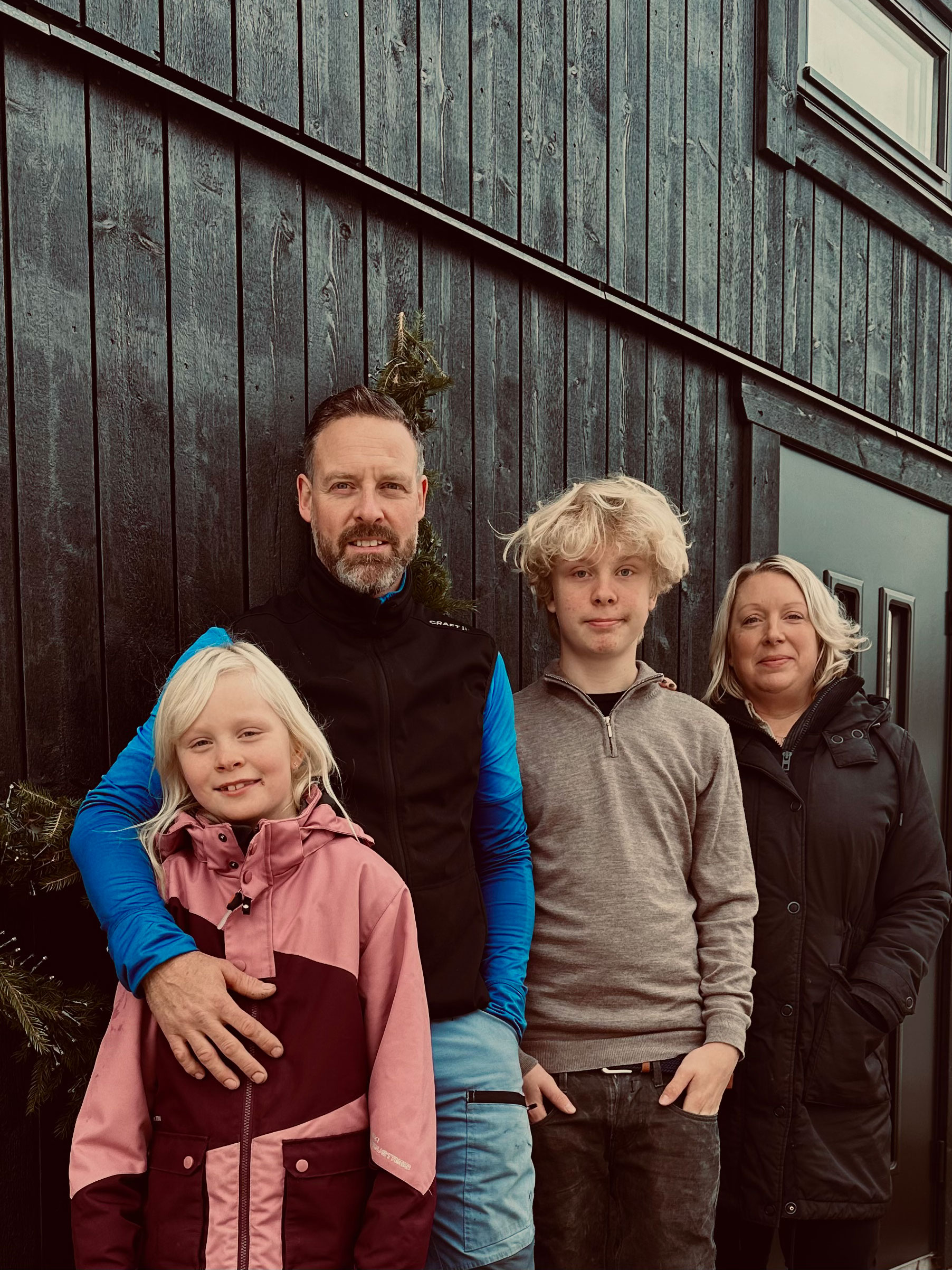 Bild på familjen framför sitt attefallshus