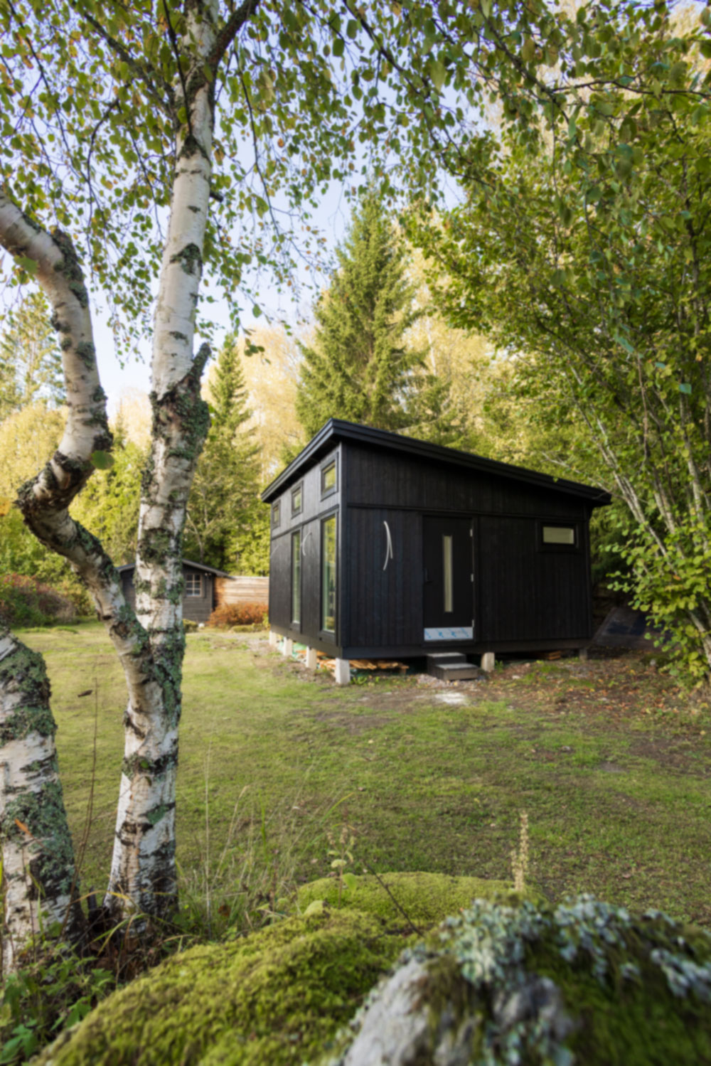 Bild på familjen framför sitt attefallshus