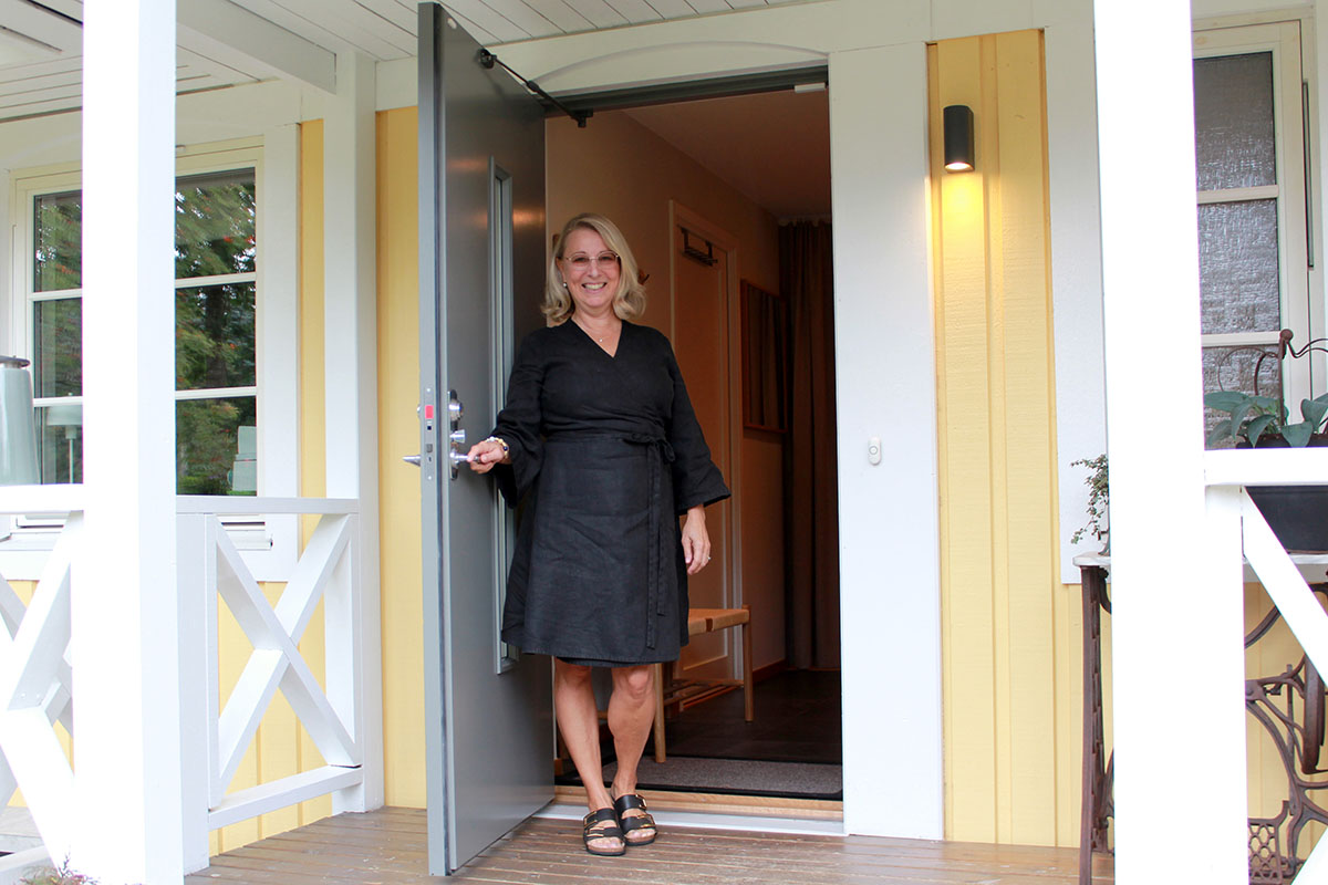 Susanne står i sin öppna ytterdörr Skanör från SKånska Byggvaror.