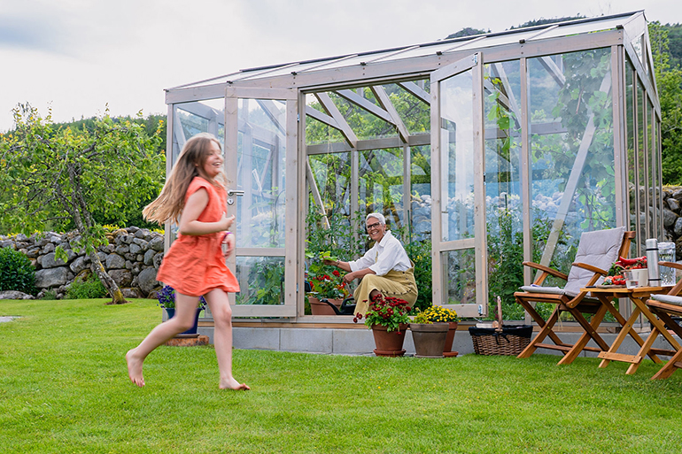Växthuset Linnea med vatten i bakgrunden.